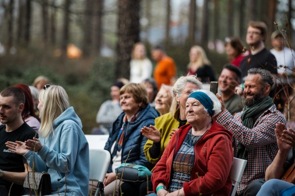 cilvēki klausās koncertu brīvdabā