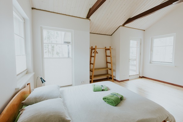 Gaiša istaba ar baltām sienām "Spāres" namiņā ar divguļamo gultu